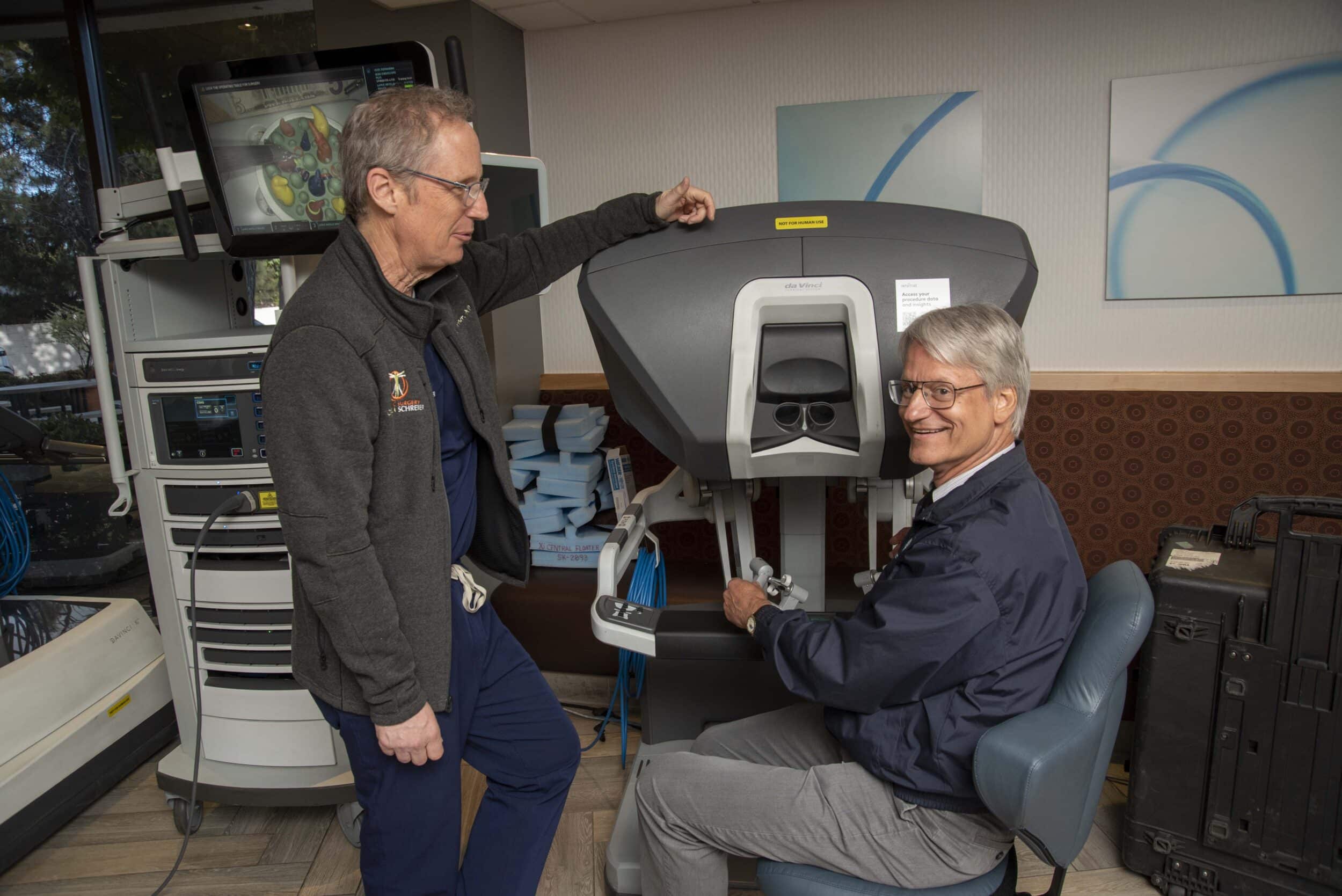 Dr. Schreier demonstrating robotic controls with colleague